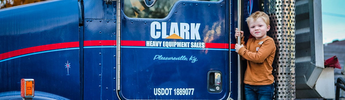 jake posing next to tractor trailer with company logo